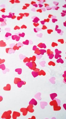 Güzel bir Sevgililer Günü kutlaması için etrafa saçılmış kırmızı ve pembe kağıt kalpler.