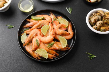 Aperatif ya da atıştırmalık konsepti için siyah kasede limonlu karides ve zeytin.