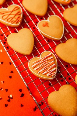 Küçük kırmızı kalplerle çevrili, rafta soğutmalı, neşeli kalp kurabiyeleri..