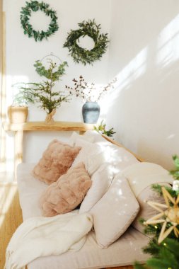 Yumuşak yastıklı rahat kanepe ve duvarında kış yeşili dekoru