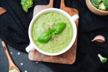 Kremalı yeşil çorba fesleğenli garnitür ahşap tahtada brokoli ile beyaz kase