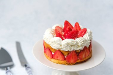 Kutlama masası ya da tatlı yemek promosyonu için kremalı tatlı konsepti olan çilekli pasta.