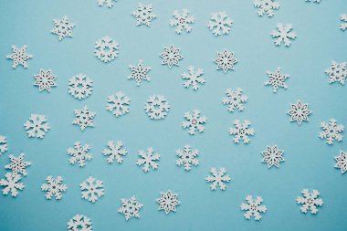 Noel için mavi zemin üzerinde kar taneleri, mevsimlik selamlama veya tatil modelleme konsepti