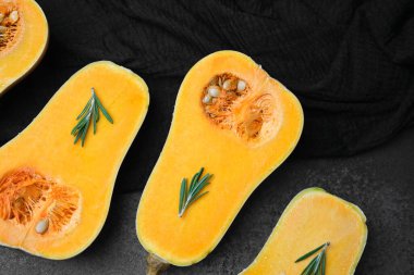 Koyu dokulu yüzeyde biberiye filizli yarım tereyağlı kabak..