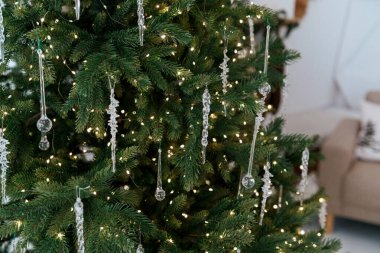 Noel ağacı dallarını, şenlikli buz saçağı süslemeleri ve ışıldayan ışıklarla kapatın.