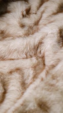 Yumuşak, açık kahverengi, sahte kürk battaniyesi, tekstil arka planının ayrıntıları.