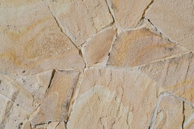 Bu topraksı arka plan taşın kaba, doğal ve çeşitli şekillerini gösteriyor..