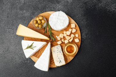 Zeytinli ve ballı peynirler ahşap bir tahtada zarif bir şekilde dizilmiş..