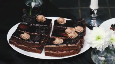 Süslü krema ve çiçeklerle servis edilen lezzetli çikolatalı kekler..