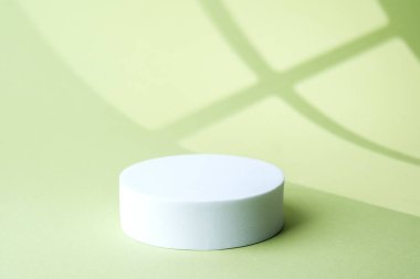 Pastel yeşilde pencere çerçevesinden beyaz dairesel kaide döküm gölgesi