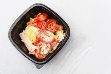 Sağlıklı öğle yemeği veya protein diyeti konsepti için marul domates kırmızı biber ve parmesan peynirli hindi salatası.