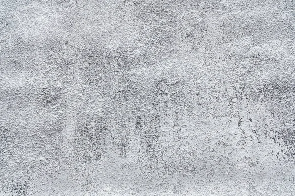 Küçük beyaz benekler ve pürüzlü yamalarla desenli gri yüzey yıpranmış bir görünüm sergiliyor..