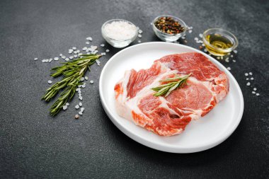 Biberiye ve baharatlı, beyaz tabakta pişmemiş biftek.