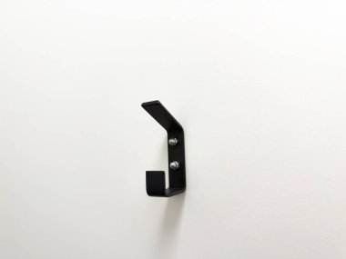 Bu sert siyah metal kanca temiz beyaz bir arkaplana karşı pratik bir depo sağlıyor.