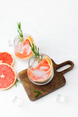 Biberiyeli greyfurt kokteyli ve narenciye dilimleri ve köpüklü sıvı içeren buz.