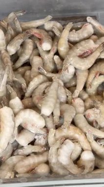 Taze çiğ kabuklu karides deniz ürünleri yığını bir market vitrininde yemek ve hazırlık için hazır.