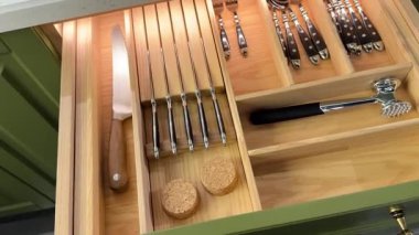 Mutfak çekmecesinde çeşitli mutfak aletleri, bıçaklar ve çatal bıçaklar var.