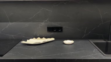 Modern mutfak tezgahı zarif tabaklar ile şık koyu mermer bir zemin