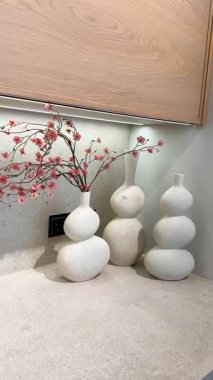 Modern seramik vazolar ve minimalist çiçeklerle süslenmiş şık bir mutfak dekoru.