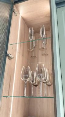 Modern raflarda çeşitli cam eşyalar sergilenen zarif mutfak dolabı.