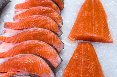 Taze, renkli somon kesimleri satılık pırıl pırıl bir buz yatağında güzelce düzenlenir..