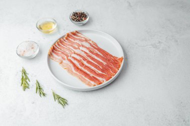 Pişmemiş pastırma şeritleri beyaz tabakta biberiye ve baharatla.