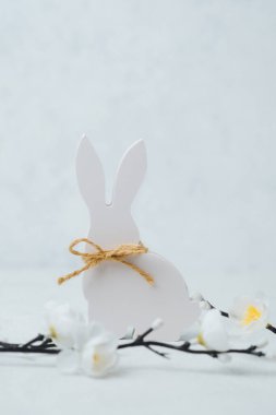 Basit bir beyaz tavşan figürü kırsal bir yay ile Paskalya eğlencesini kutluyor.