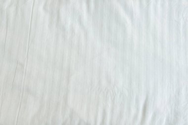 Beyaz pamuk kumaş dokusu, yumuşak buruşuk, temiz bir zemin için ince dikey çizgiler..