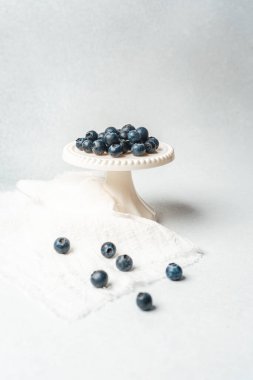 Yaban mersini, yumuşak bir arkaplanda küçük beyaz bir stantta güzelce sergilenir..