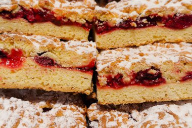 Bu lezzetli pasta kareleri zengin bir kiraz dolgusu ve şekerle kaplanmış parçalanmış bir üst içerir..