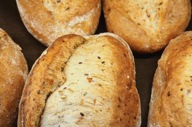 Birkaç altın tohumu, karanlık bir yüzeyde duruyor..