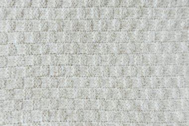 Açık gri desenli kumaş, kare waffle deseninin yakın plan görüntüsünü oluşturur..