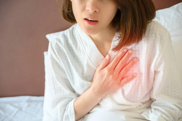 Close-up of woman having chest pain or heart attack. Conceptual of heart disease/ chest pain can indicate a serious problem, it's important to seek immediate medical help.