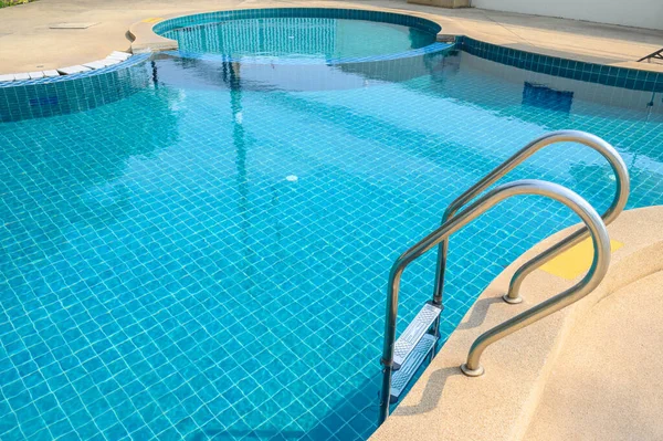 A metal grab bars ladder in hotel swimming pool. Swimming pool designed to hold water for leisure activities or enable swimming.