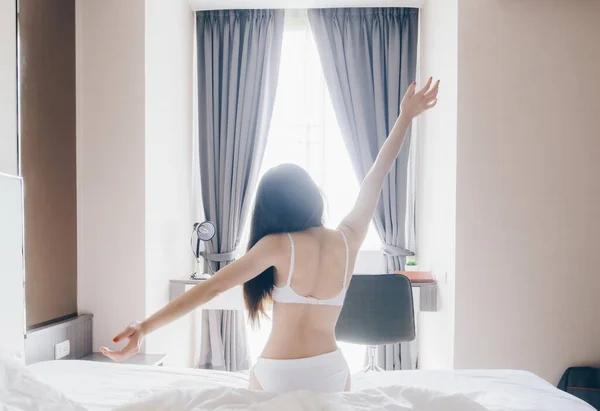 早上醒来后 女人穿着内衣裤躺在宾馆的卧室里 带着快乐开始新的一天 女性生活方式的肖像 — 图库照片