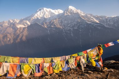 Nepal 'in Annapurna bölgesindeki Mardi Himal perspektifinden güzel manzaralı bayraklar (7.219 m) ve Hiunchuli Dağı (6.441 m) görülüyor..