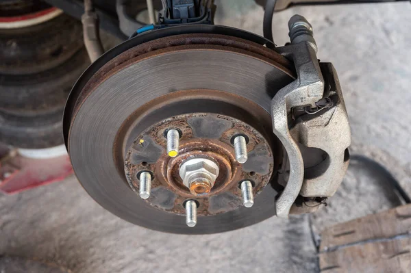 Garajda tamirat beklerken bir araba tekerleği ve disk frenini kapat..