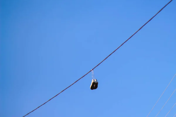 Elektrik Tellerinden Sarkan Defocus Spor Ayakkabıları Mavi Gökyüzü Arka Planına — Stok fotoğraf