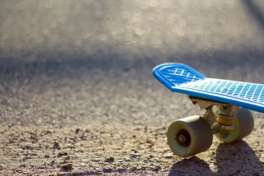 Defocus, sabah parkta mavi kaykayı kapat. Kamu parkında kaykay ve tekerlek sorumlusuyum. Spor konsepti. Bulanık bokeh. Modern fon. Odaklanamıyorum.