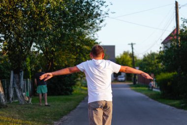 Defocus mutlu genç çocuk sokakta kaykay oynuyor. O, kollarını yanlara doğru uzattı. Beyaz çocuklar peni tahtasında kaykay yapıyorlar. Çocukluk eğlence özgürlük konsepti. Odaklanamıyorum.