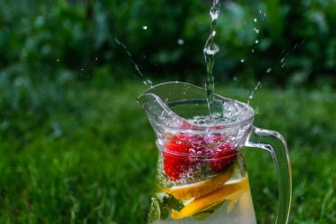 Defocus jet, cam sürahi limonata, çilek ve nane arkaplanda su damlalarıyla birlikte su kabarcıkları püskürtür. Bir sürahi limon likörü. Uzayı kopyala Odaklanamıyorum.