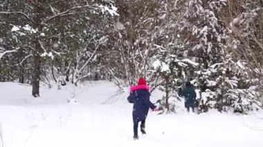 Defocus çocuğu bir kızla kartopu sallıyor. Winter Park 'ta kar topu oynayan komik çocuklar, dışarıda zaman geçirmek. Kış karlı ormanlık. Soğuk soğuk hava. Ergenlik. Kardeş. Kış çocukları oyunu. Odaklanamıyorum.