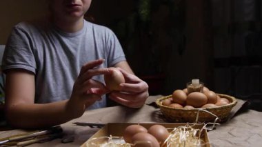 Genç bir kadın yumurtayı tutuyor ve çeviriyor. Folk tasarımlarıyla süslenmiş Ukrayna Paskalya yumurtalarını boyamaya hazırlanıyorlar. Pysanka, Paskalya yumurtası. İyi geceler. El yapımı..