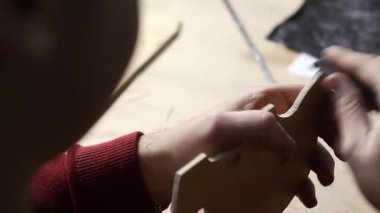 Kırmızı kollu zımpara kağıdıyla zımparalanmış kontrplak parçası. Ayrıntılı ahşap işleme süreci.