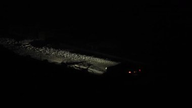 Ukrayna 'da elektrik kesintisi. Kışın zifiri karanlık bir caddede araba sürüyor. Kar sadece farları aydınlatıyor..