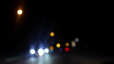 Gece Yolu Şehri Bokeh. Karanlık bir kış otobanında araba farlarının ve sokak ışıklarının soyut bulanık arkaplanı.