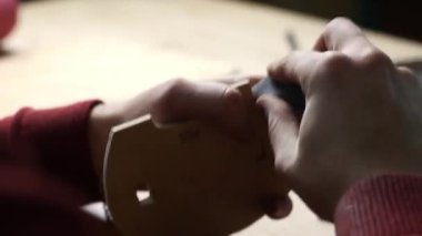 Zımpara kağıdıyla ahşap ya da kontrplak parçası zımparalayan bir zanaatkarın yakın çekimi. Marangozluk atölyesi ve el yapımı mobilya üretim konsepti.