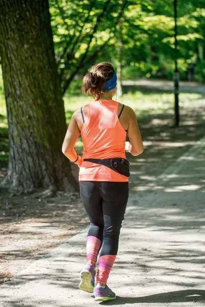 Jonge vrouwelijke jogger in park — Stockfoto