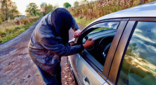 Hooligan bricht in Auto ein — Stockfoto