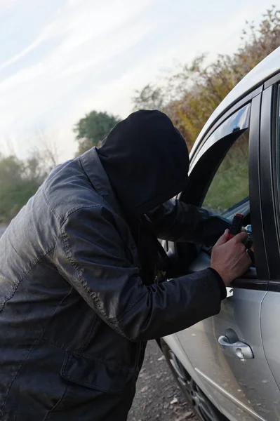 Hooligan breaking into car — Stock Photo, Image